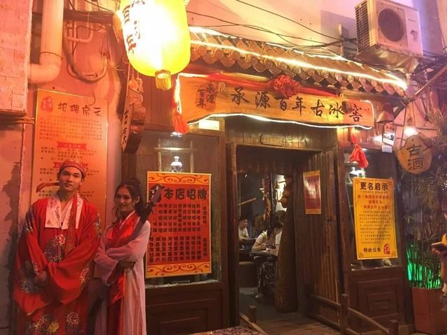 太平街上一家酒馆门外,站在门口的店员。
